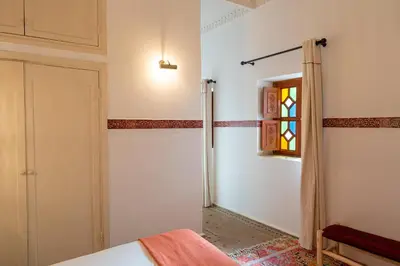 a bedroom with a bed and a window and a door at Riad Le Marocain in Marrakech