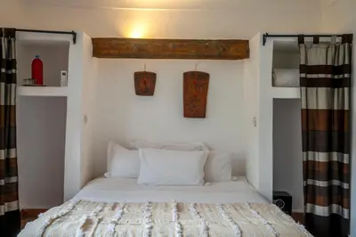 a bedroom with a bed with white pillows at Riad Nora in Marrakech