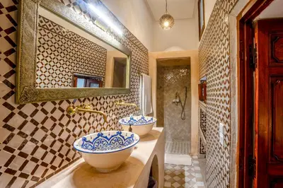 a bathroom with two sinks and a mirror at Riad Nora in Marrakech