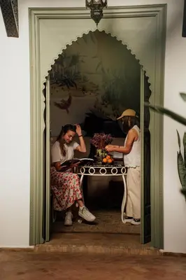 a woman sitting at a table in a room at Riad Bab 54 in Marrakech