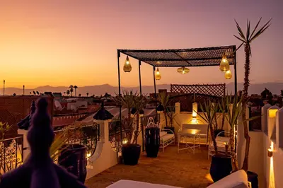 a person standing on a balcony at sunset at Maïpa Boutique Riad in Marrakech
