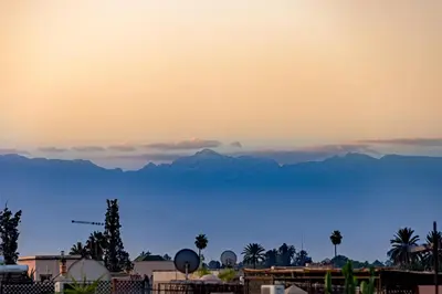 a view of a mountain range with palm trees and buildings at Maïpa Boutique Riad in Marrakech