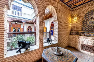a room with a table and a statue in the window at Maïpa Boutique Riad in Marrakech