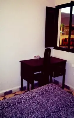 a bedroom with a desk with a chair and a mirror at Riad Elizabeth in Marrakech