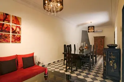 a living room with a red couch and a table at Riad Elizabeth in Marrakech