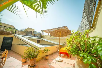 a balcony of a house with plants and an umbrella at Riad Euphorbe in Marrakech