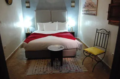 a bedroom with a large bed with a red blanket at Riad Le Plein Sud in Marrakech