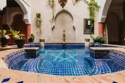 a swimming pool in a house with blue tiles at Riad Le Plein Sud in Marrakech