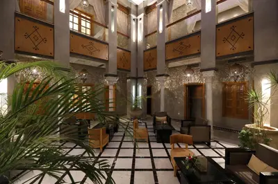 a lobby with chairs and tables in a building at Riad L'Etoile D'Orient in Marrakech