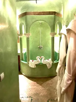 a bath room with swans in a green room at Riad Fatinat Marrakech in Marrakech