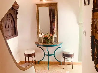 a dressing table with two stools and a mirror at Dar Zemrane in Marrakech