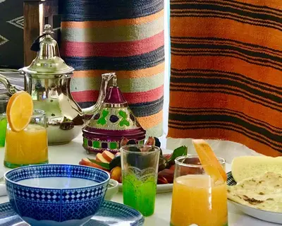 a table topped with plates and glasses of orange juice at Dar Zemrane in Marrakech