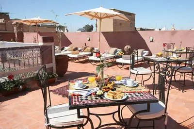 a patio with tables and chairs with food on it at Riad Shaloma in Marrakech