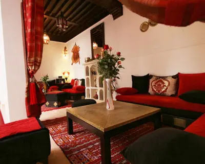 a living room with a red couch and a table at Riad Shaloma in Marrakech