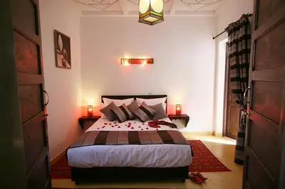 a bedroom with a bed and two lamps and a door at Riad Shaloma in Marrakech