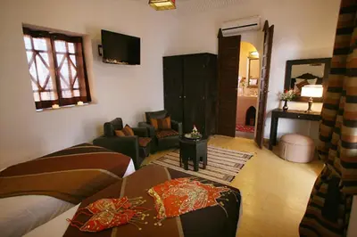 a bedroom with two beds and a living room at Riad Shaloma in Marrakech