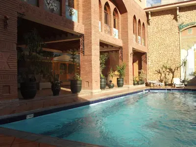 a swimming pool in the middle of a building at Hotel Al Kabir in Marrakech