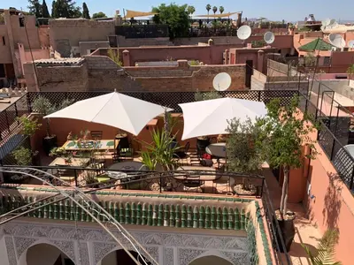 a patio with umbrellas and tables on a building at Riad Abaka hotel & boutique in Marrakech