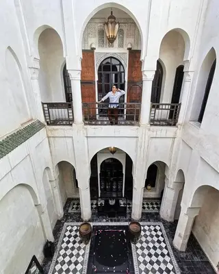 a man standing on a balcony of a building at Dar Darma in Marrakech