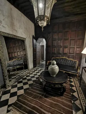 a room with a table and a couch and a mirror at Dar Darma in Marrakech