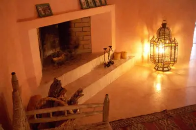a living room with a fireplace and a chandelier at Dar El Kharaz in Marrakech