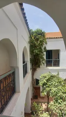 an archway of a building with a tree in the courtyard at Dar El Kharaz in Marrakech