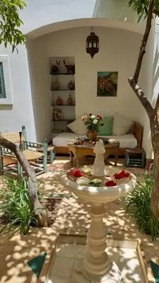 a living room with a table and a fountain at Dar El Kharaz in Marrakech