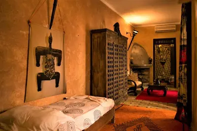 a bedroom with a bed and a living room at Riad Bamileke in Marrakech