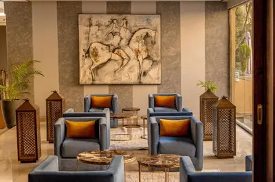 a lobby with chairs and tables and a painting of a horse at Grand Plaza Marrakech in Marrakech