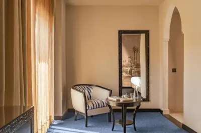 a room with a chair and a table and a mirror at Grand Plaza Marrakech in Marrakech