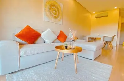 a living room with a white couch and a table at Marrakech golf city prestigia in Marrakech