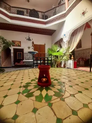 a living room with a red stool on a tiled floor at Riad Chennaoui in Marrakech