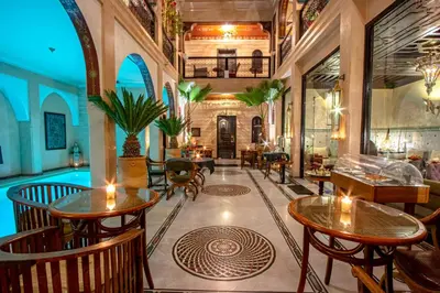 a lobby with tables and chairs and a pool at Dar Anika in Marrakech