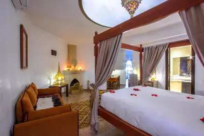 a bedroom with a large bed and a fireplace at Dar Anika in Marrakech
