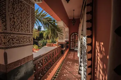 an outside balcony of a house with a palm tree at Palais Dar Donab in Marrakech