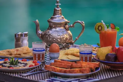 a table topped with plates of food and a tea kettle at Palais Dar Donab in Marrakech