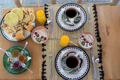 a table with plates of food and cups of coffee at Riad Ksar Fawz & Spa in Marrakech