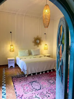 a bedroom with a bed with a pink rug at Riad Ksar Fawz & Spa in Marrakech