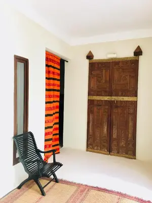 a black chair in a room with a door at Riad Alia in Marrakech