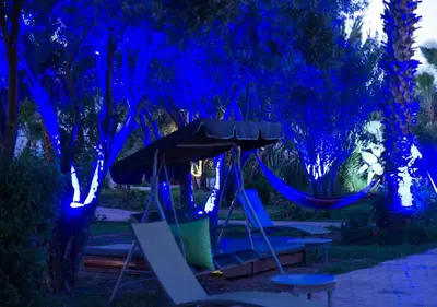 a hammock in a garden at night with blue lights at Le Relais De Marrakech in Marrakech