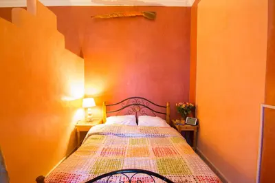 a bedroom with a bed with an orange wall at Le Relais De Marrakech in Marrakech