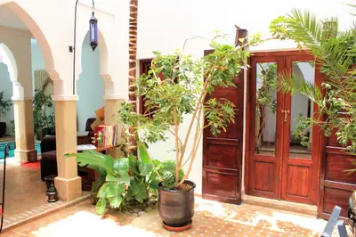 a room with many plants and a wooden door at Les Jardins Mandaline in Marrakech