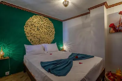 a bedroom with a bed with a green wall at Riad Safran et Cannelle & Spa in Marrakech