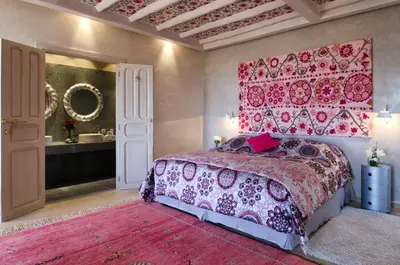 a bedroom with a large bed with a pink head board at Tigmiza Boutique Hotel & Spa in Marrakech