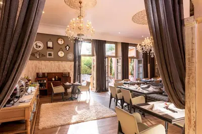 a dining room with tables and chairs and a chandelier at Tigmiza Boutique Hotel & Spa in Marrakech