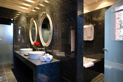 a bathroom with two sinks and a tub and mirrors at Tigmiza Boutique Hotel & Spa in Marrakech