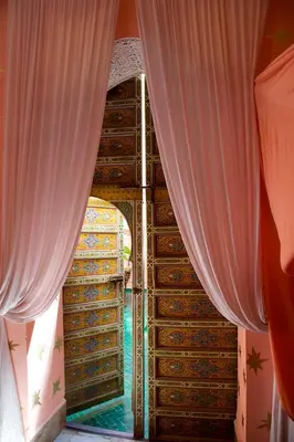a view of a swimming pool through the curtains at The Bohemian Jungle in Marrakech