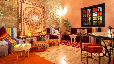 a living room with colorful furniture and stained glass windows at Riad Leila Marrakech in Marrakech