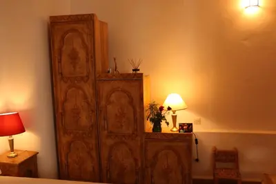a large wooden cabinet in a room with a lamp at Riad Chergui in Marrakech