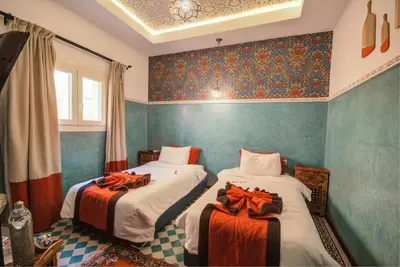 two beds in a room with blue walls at Riad Les Oliviers & Spa in Marrakech